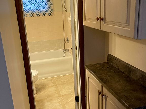 short hall to bathroom, also extra cabinets on the right
