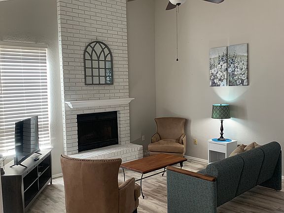 Living room with ceiling fan and hearth. *(The fireplace is not for use.)