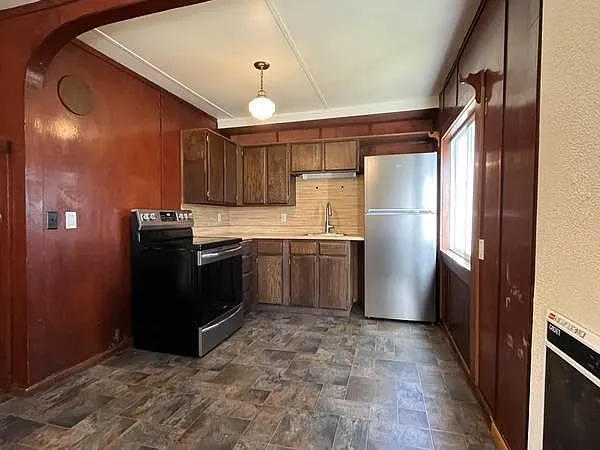 The kitchen is equipped with a stainless steel refrigerator and a sleek stove, ready to inspire your culinary creations.