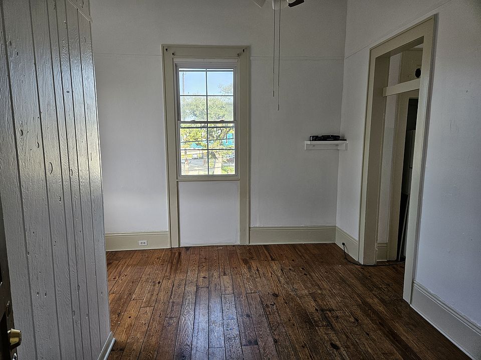 FRONT ROOM ENTRANCE WITH WINDOW VIEW OF N CARROLLTON AVENUE WHERE ENDYMION PARADE PASSES IN FRONT