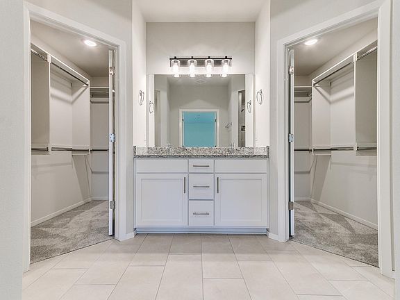 Stunning and functional bathroom design with a walk around closet and a double sink vanity