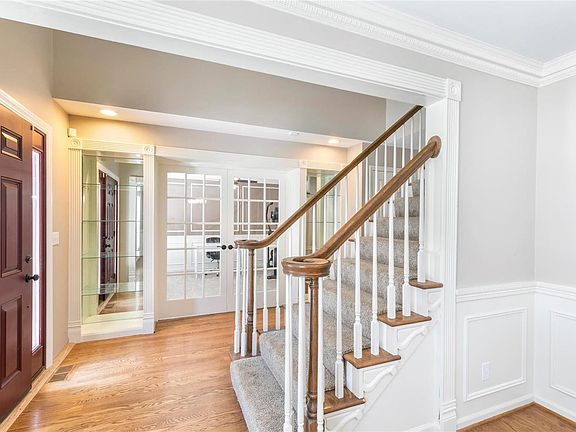 Entry foyer with hardwood flooring, beautiful moldings and built in shelving