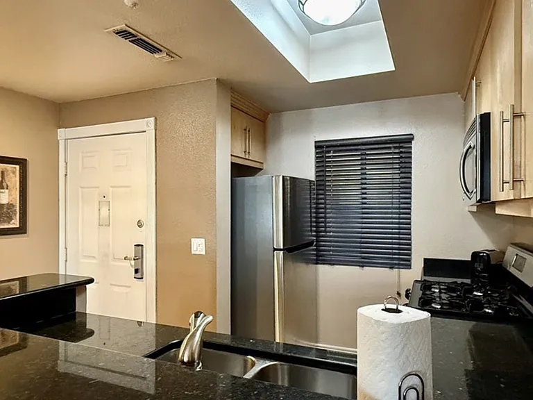 Fully equipped kitchen with pots, pans, dishes, and utensils.