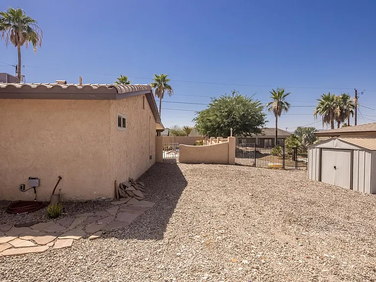 Low-maintenance gravel side yard with gated access.