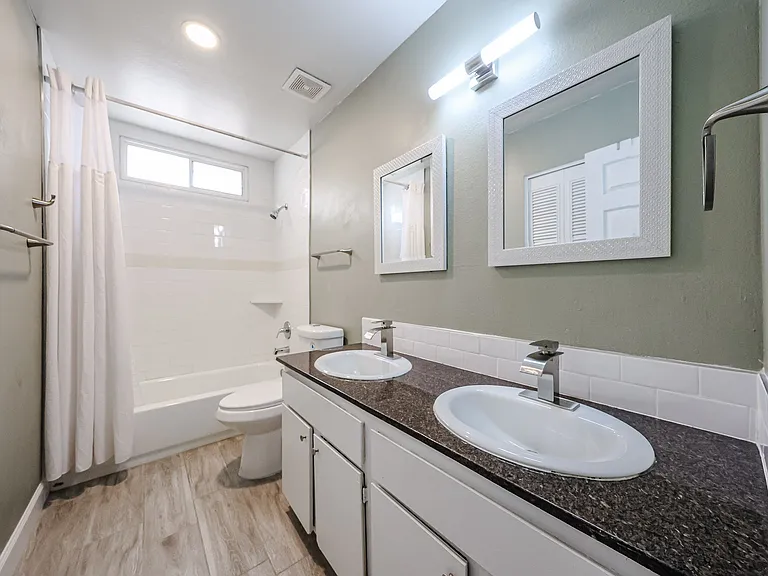 Hall Bath. Dual sink, granite countertop, tiled tub and shower