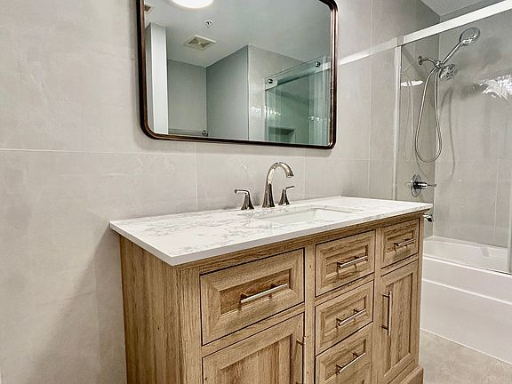 Beautiful bathroom vanity featuring rich wood craftsmanship, generous storage, and a well-lit mirror for a warm, modern finish.