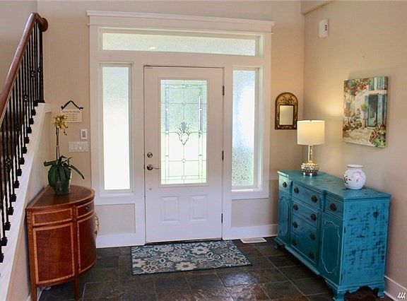 This elegant entry features beveled glass door with side lights and transom window, two story high ceiling and slate floor.  Notice the wide casing that adds nice detail throughout the interior of this home.