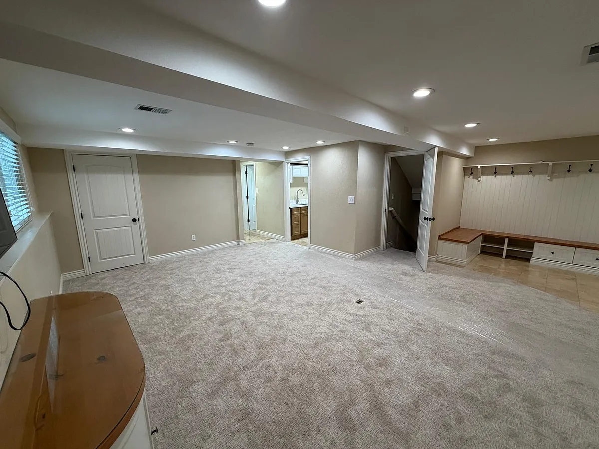 Living room with door to downstairs bedroom, door to shared laundry/sink area - S Jay St