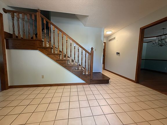Foyer from front door, showing family room to the left, staircase to second floor, hallway, and dining room to the right