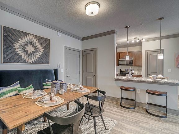 Kitchen with pendant lighting and dining area with hard-surface flooring