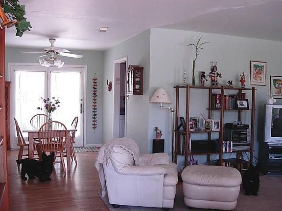 Living room and dining room with wood floors and access to large back yard.