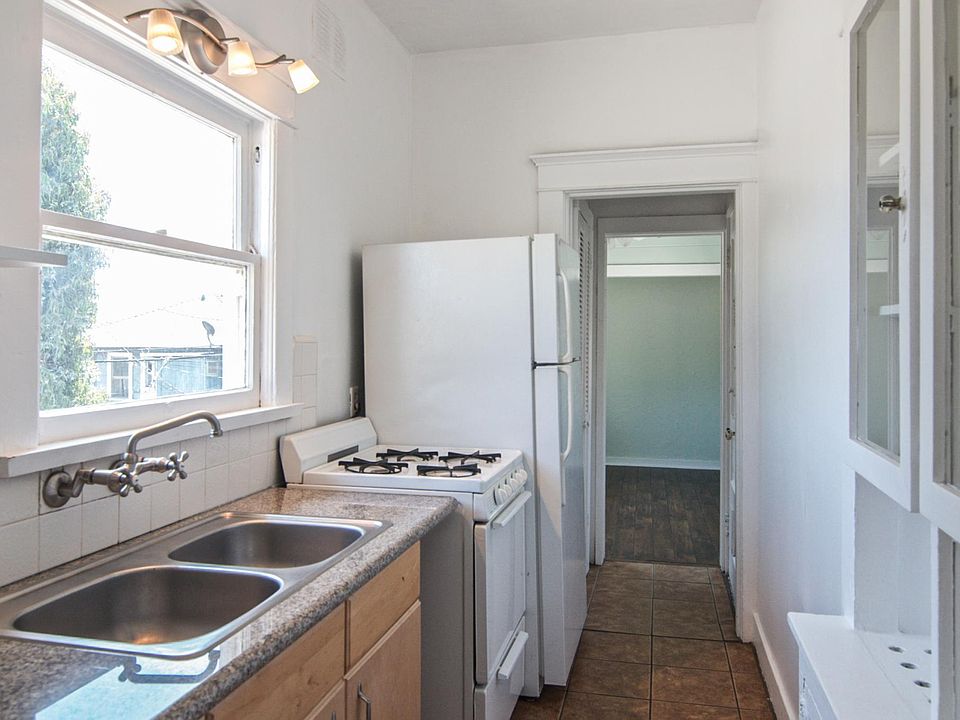 Bright galley kitchen with bedroom beyond 