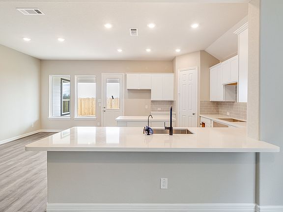 Spacious kitchen featuring a large peninsula and center island with space for a breakfast table and