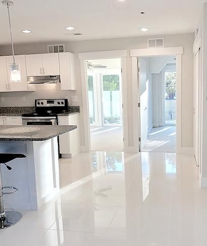 The Kay: 2BD / 1BA. Ultra-modern white tile. Shown with kitchen island.