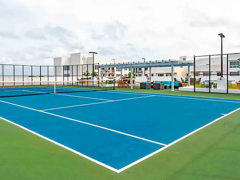 Luxury apartment community rooftop tennis court with city views and professional surface