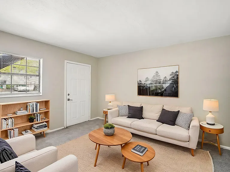 Bright and cozy living room featuring a modern beige sofa, stylish coffee tables, and elegant decor, perfect for relaxation and comfort.