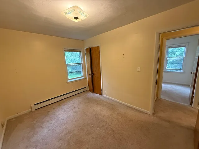 second smaller bedroom with one window and smaller closet