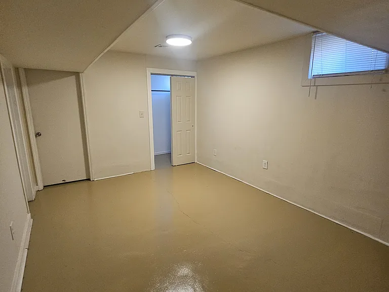 Bedroom in the back right of the basement. Has its own closet in the back right. The door in the back leads to a storage area. There is a door back left that leads to a shared walk-in closet.