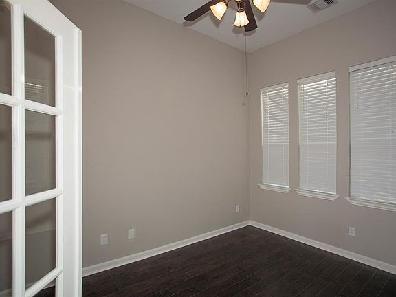Tall windows in the home office invite in views to the blooming front yard...