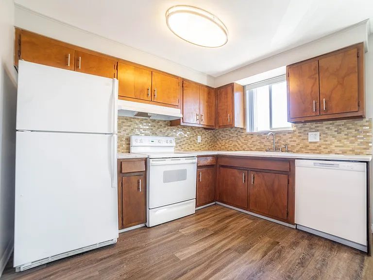 Charming kitchen with warm wooden cabinets, modern appliances, and elegant tile backsplash, offering a perfect blend of style and functionality.