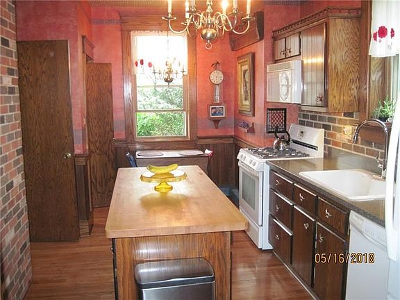 Updated kitchen custom cabinets, newer solid surface counters, sink, dishwasher and refrigerator. walk in pantry, gas stove, pew