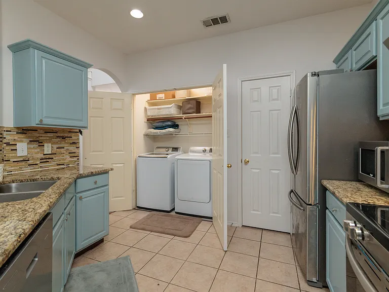 Open kitchen concept with all the major appliances with 2 bar top stools by the pass through. With the washer/dryer in laundry closet.