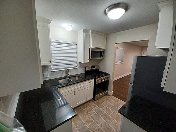 Fully furnished kitchen with gas range, microwave, dishwasher, refrigerator and plenty of counterspace.