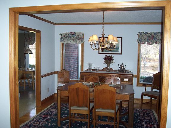 Open floor plan Dining Room with stain-grade baseboards, chair rail & crown.