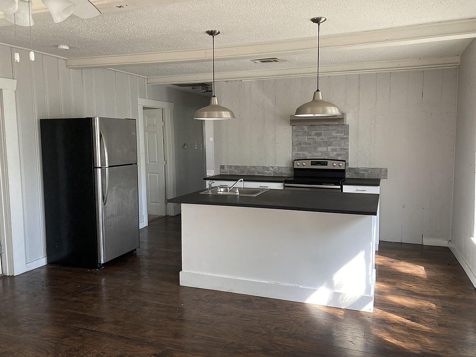 Kitchen with island, fridge, and stove all included. Hardwood flooring throughout living areas