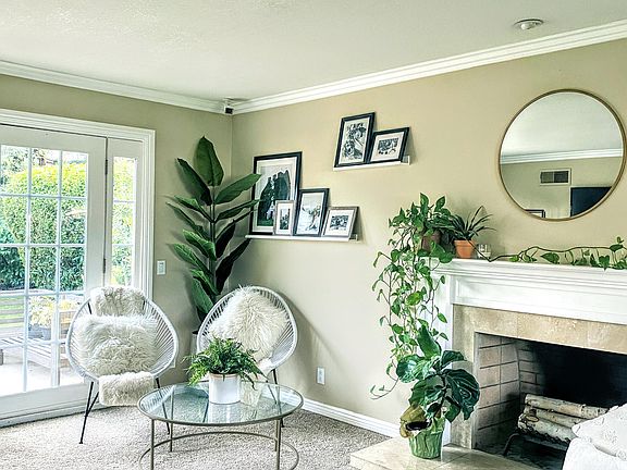 The living room features French doors and a custom wood-burning fireplace with a travertine surround. Extend your outdoor/indoor entertaining space by opening the French doors to the backyard.