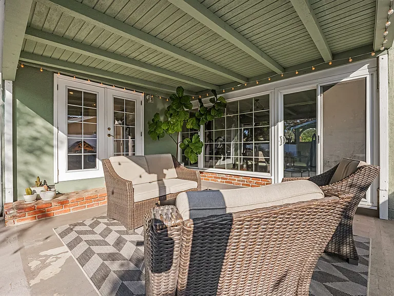 Spacious, fully fenced backyard with two distinct patio sections and seating in each.