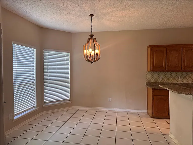 Dining area with tile flooring and a suspended chandelier