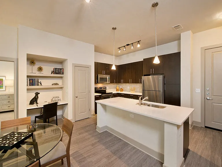 Open-concept gourmet kitchens with stainless steel appliances, granite slab countertops, custom cabinentry, and natural stone backsplash