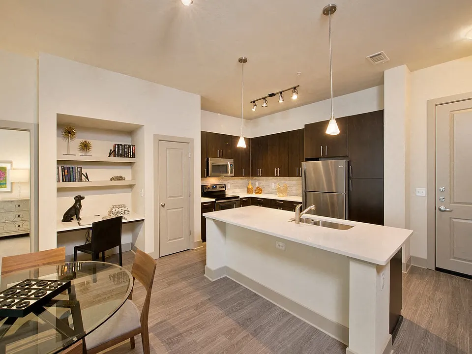 Open-concept gourmet kitchens with stainless steel appliances, granite slab countertops, custom cabinentry, and natural stone backsplash