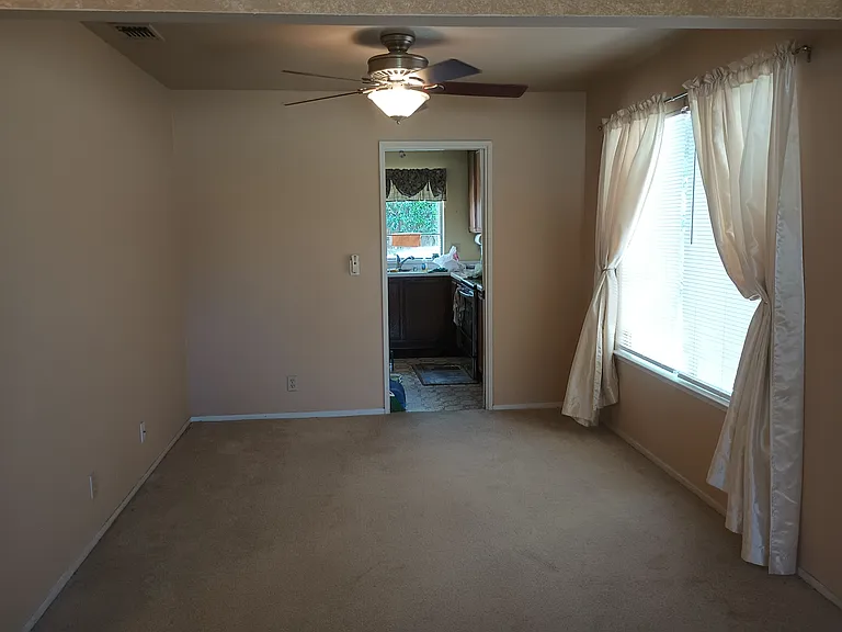 Formal dining room with ceiling fan, window blinds/drapery