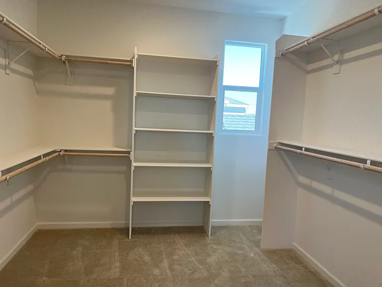 Primary Walk in Closet: An enormous walk-in closet with custom shelving and hanging space to spare. Room for two, easily.