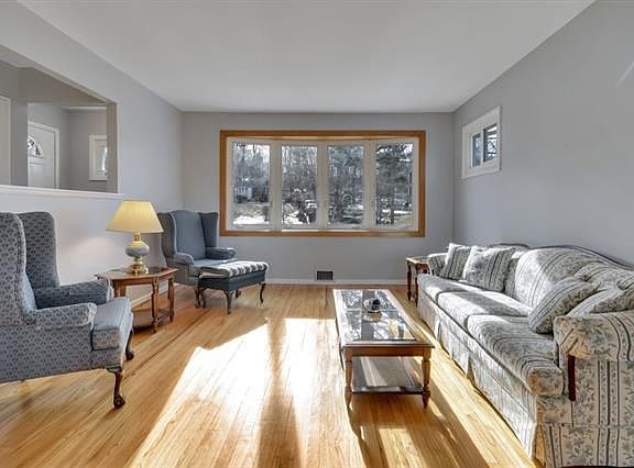The form living room with a bay window overlooks the landscaped front yard.