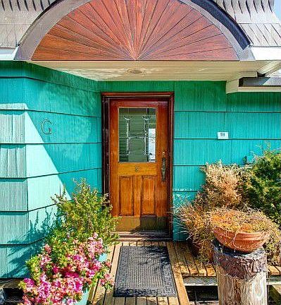 Charming entry features copper roof detailing, a leaded glass door and an inspiration for the container gardener.
