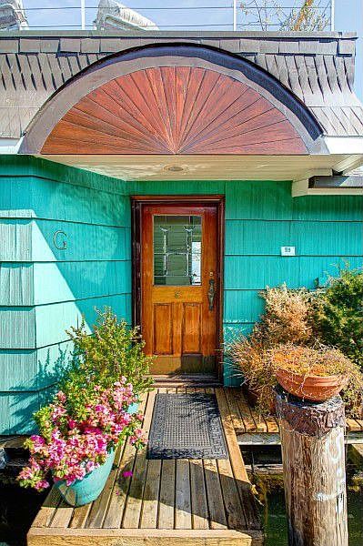 Charming entry features copper roof detailing, a leaded glass door and an inspiration for the container gardener.