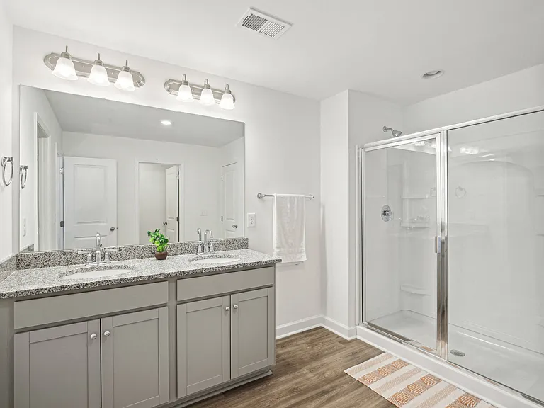 Primary bathroom featuring a double vanity and walk-in shower.