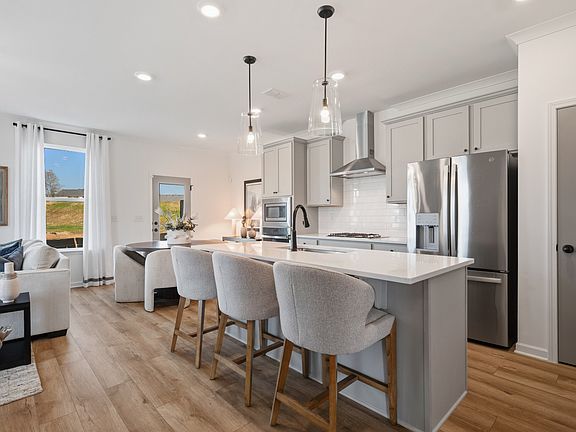 Bright open kitchen with quartz island and modern finishes in Langley Overlook townhome in Loganvill