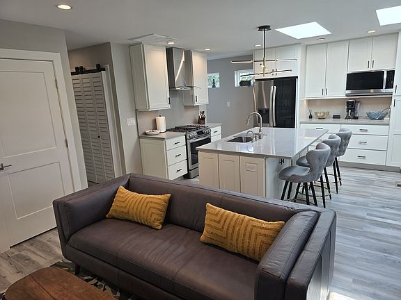 Living/Dining/Kitchen. 2 closets left of sofa. One is coats, the other for storage. Laundry left of oven/hood.