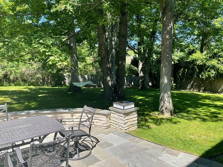 Bluestone patio with dining for six. with additional seating along flagstone wall.