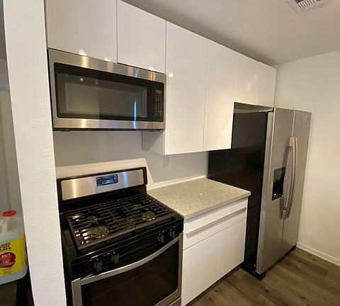 new stove, microwave, fridge, countertops, and cabinets.