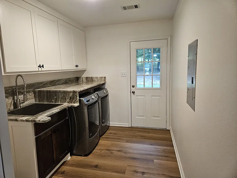 Laundry room with sink and new washer and dryer.