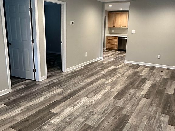 View from front corner of the living/dining room showing entry to bedrooms and kitchen