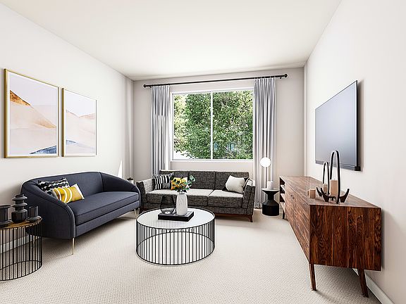 A cozy living room with a comfortable sofa, a wooden cabinet, and a framed artwork on the wall, over