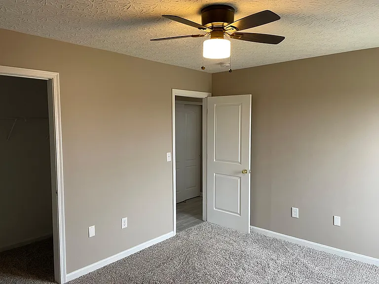 Master bedroom looking into hall. New carpet, paint and ceiling fan. Barn door will be installed on large walk in closet.