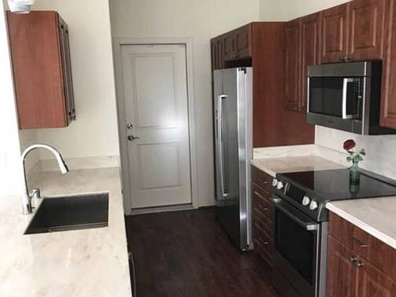 Kitchen with stainless steel appliances and gorgeous countertop, with door access to attached 2 car garage.