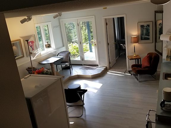 Spacious Great Room With Dining and Sitting Areas, Views of Private Deck, Forest, Gardens